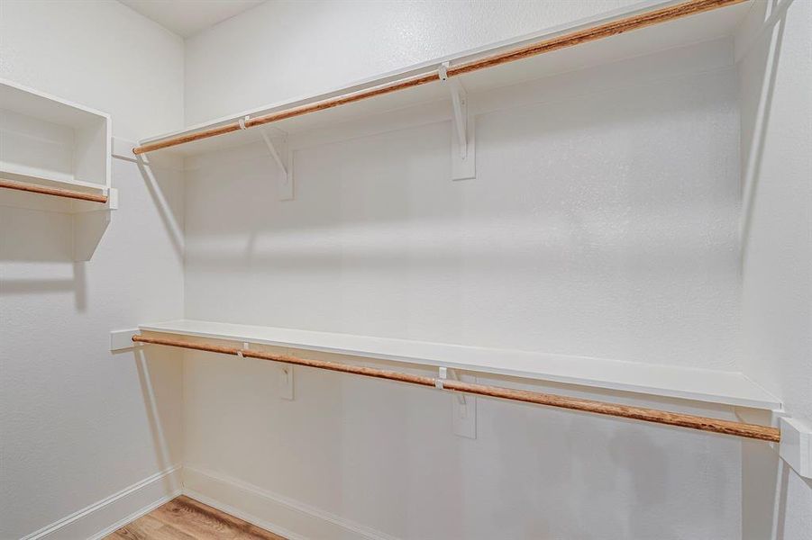 Walk in closet featuring light wood-style flooring Walk in closet featuring light wood-style flooring