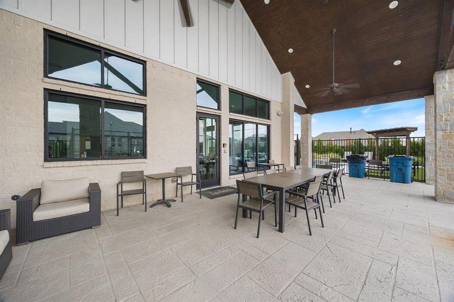 Community patio at clubhouse featuring outdoor dining space and ceiling fan