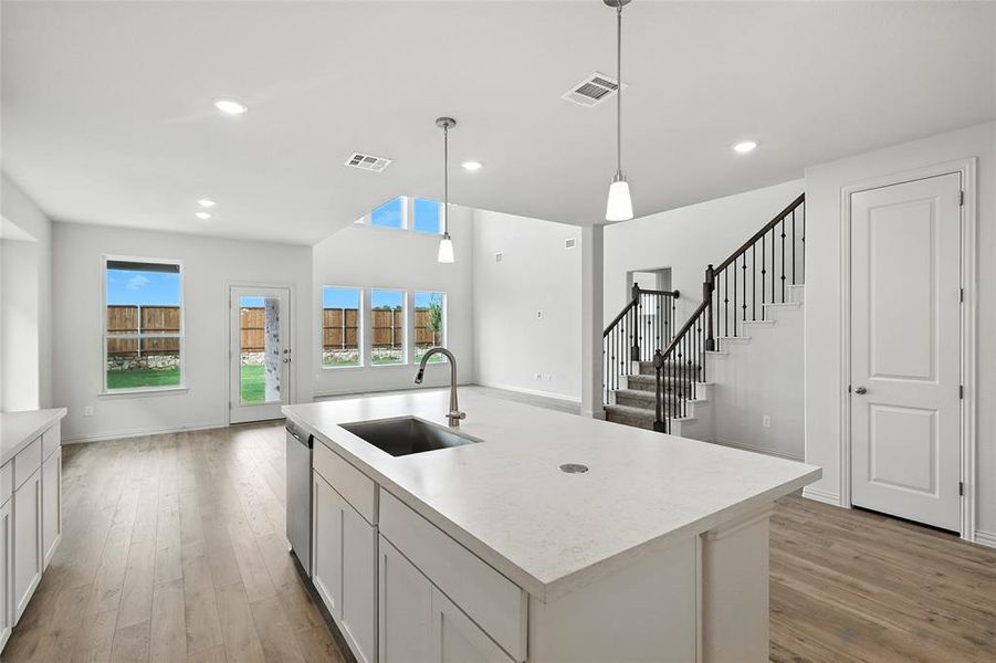 Kitchen with light countertops, white cabinets, light wood-type flooring, healthy amount of natural light, and recessed lighting