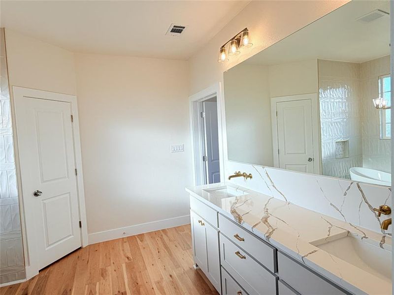 Bathroom with double vanity and light wood finished floors Bathroom with double vanity and light wood finished floors