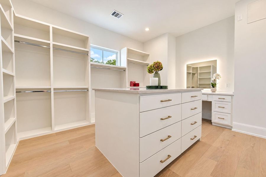 Boutique-inspired primary closet featuring extensive custom built-ins, floor-to-ceiling shelving, and a spacious center island with abundant drawer storage. Thoughtfully designed to beautifully organize and display an impressive wardrobe, this sophisticated dressing space brings a custom, high-end feel to the primary suite. Boutique-inspired primary closet featuring extensive custom built-ins, floor-to-ceiling shelving, and a spacious center island with abundant drawer storage. Thoughtfully designed to beautifully organize and display an impressive wardrobe, this sophisticated dressing space brings a custom, high-end feel to the primary suite.