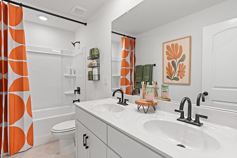 A bathroom with a sink toilet and a mirror. A bathroom with a sink toilet and a mirror.