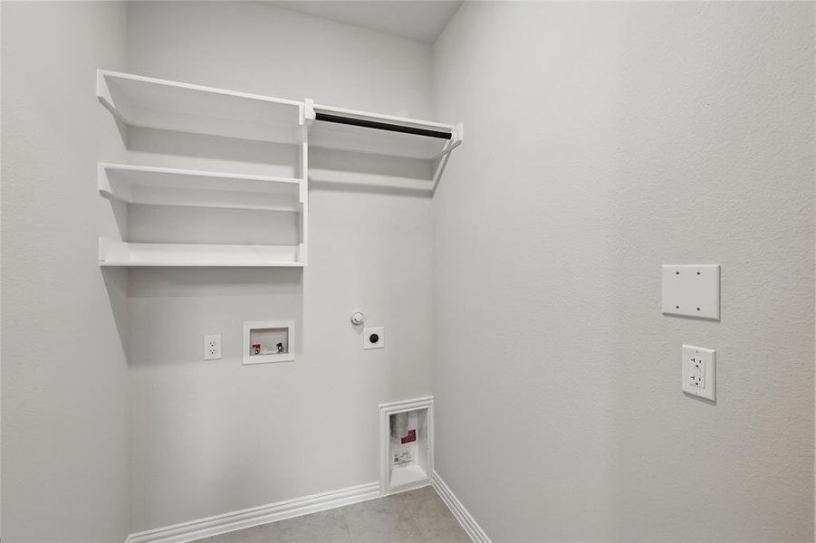 Washroom with hookup for an electric dryer, hookup for a washing machine, and hookup for a gas dryer