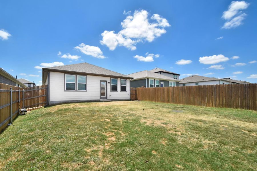 A spacious backyard provides ample green space, enclosed by a privacy fence, perfect for outdoor entertaining A spacious backyard provides ample green space, enclosed by a privacy fence, perfect for outdoor entertaining