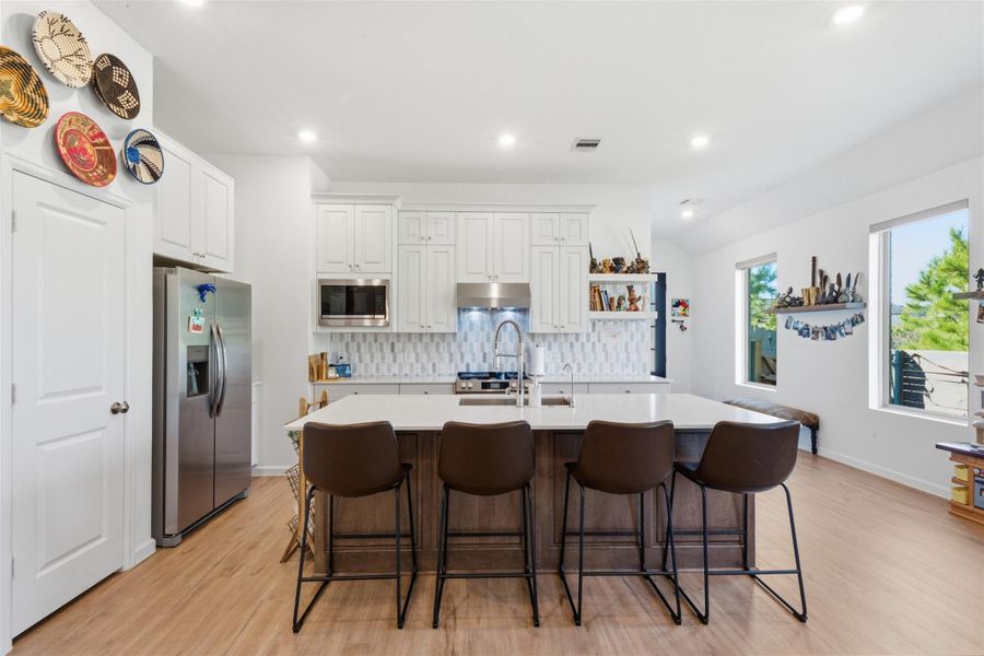 The open layout is accentuated by bright natural light from multiple windows, and decorative wall accents add a personal touch.