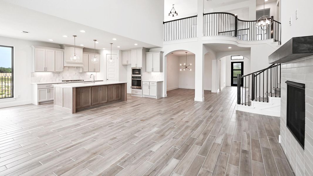 Kitchen featuring arched walkways, light countertops, a chandelier, open floor plan, and stainless steel microwave Kitchen featuring arched walkways, light countertops, a chandelier, open floor plan, and stainless steel microwave