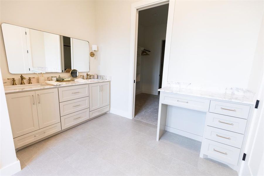Dual vanity with light-colored cabinetry and marble-patterned countertops