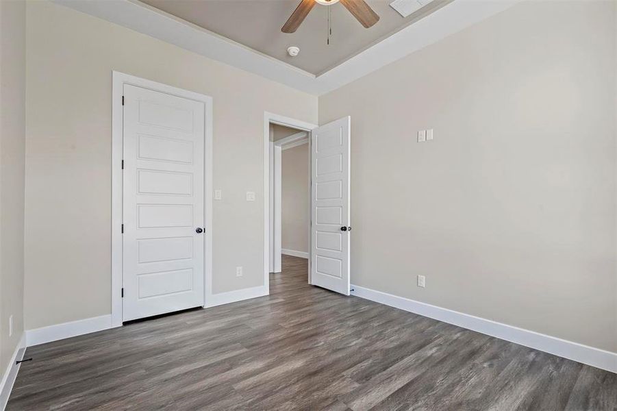 Unfurnished bedroom featuring ceiling fan and dark hardwood / wood-style floors