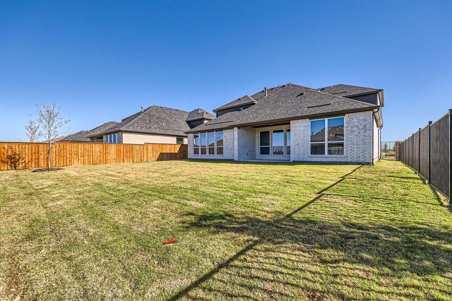 Rear view of house featuring a yard