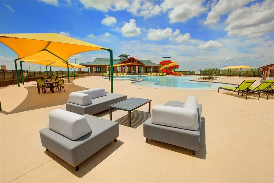 Resort-style pool area featuring a winding pool, multiple water slides, and a sun deck