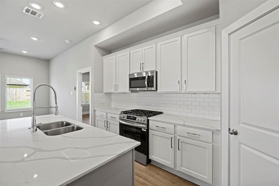 Stunning modern kitchen with sleek cabinetry, quartz countertops, and stainless steel appliances.