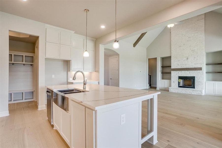 Kitchen featuring built in features, a fireplace, white cabinetry, and light hardwood / wood-style floors