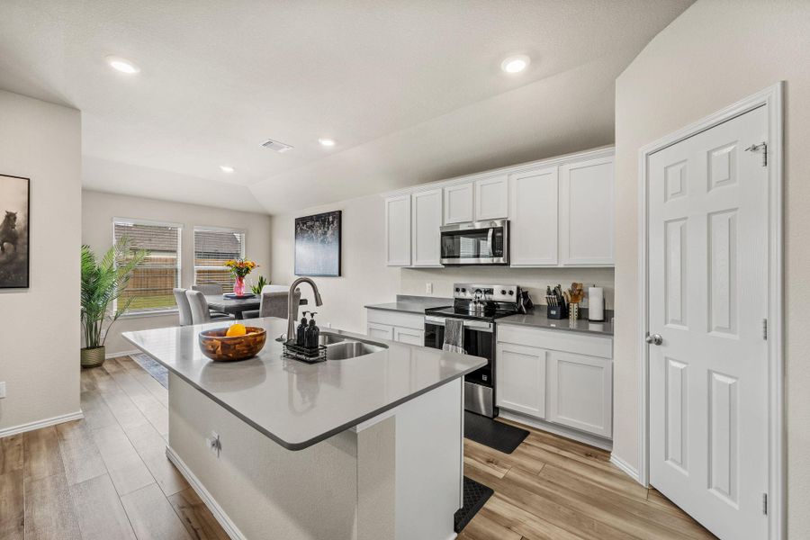 The kitchen's island sink and stainless steel appliances create a functional and appealing culinary space.