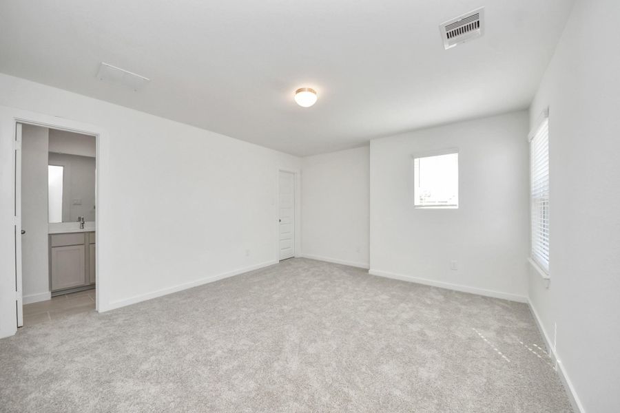 Secondary bedroom features plush carpeting, large windows that let in plenty of natural light, bright paint, and spacious closets. Sample photo of completed home with similar floor plan. Actual colors and selections may vary.