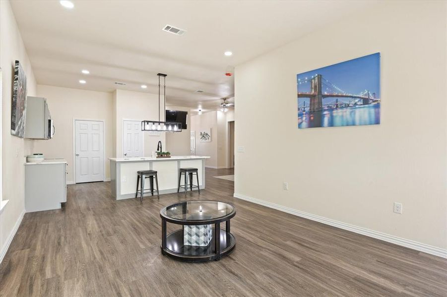 Living room with ceiling fan, dark hardwood / wood-style floors, and sink