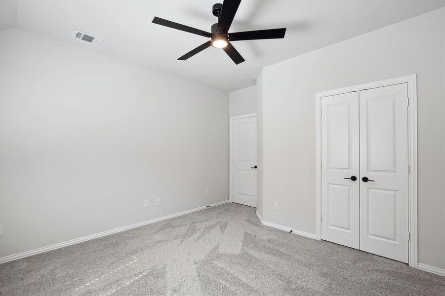Unfurnished bedroom with carpet, baseboards, a closet, and ceiling fan