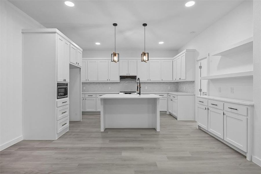 Kitchen featuring pendant lighting, decorative backsplash, white cabinetry, and recessed lighting Kitchen featuring pendant lighting, decorative backsplash, white cabinetry, and recessed lighting