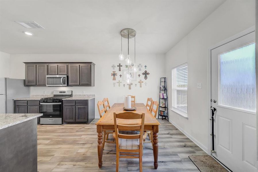 Dining area with light wood-style floors and recessed lighting