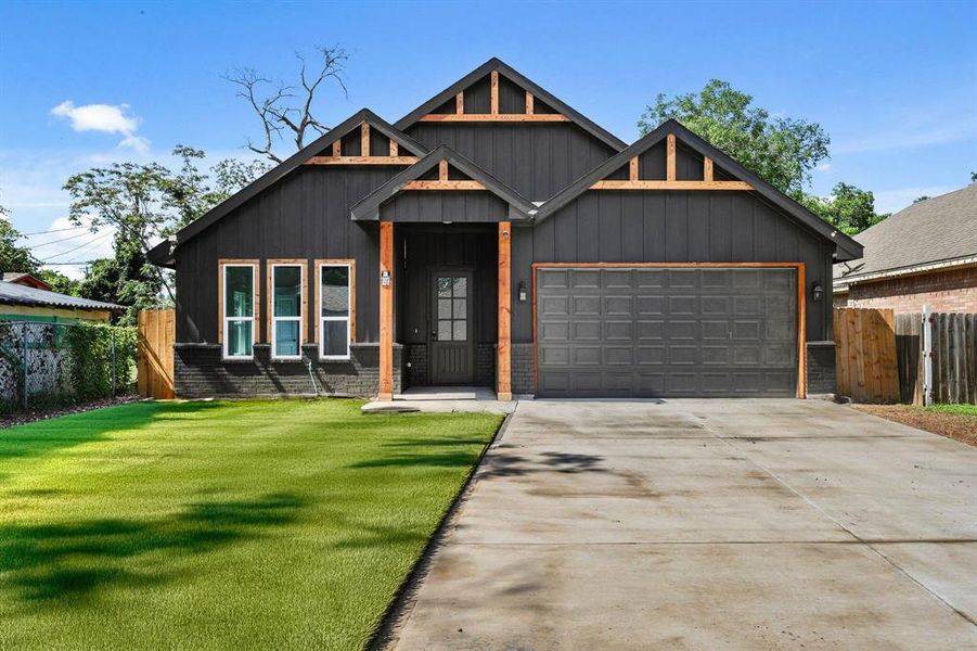 View of front of property featuring an attached garage, concrete driveway, and board and batten siding