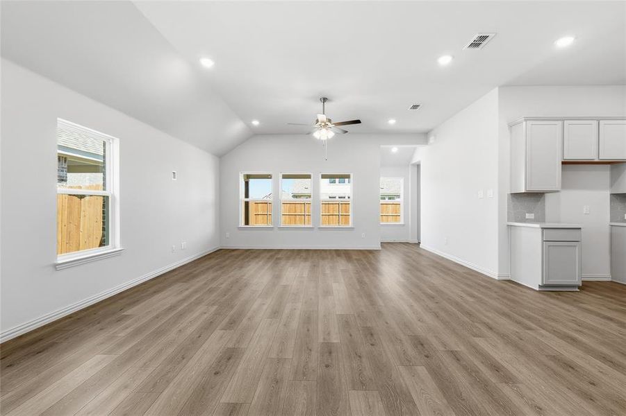 Unfurnished living room with recessed lighting, vaulted ceiling, ceiling fan, and light wood finished floors