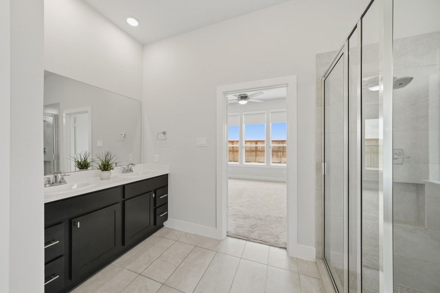 Relax and unwind in the spacious primary bath featuring dual vanities and modern finishes. Relax and unwind in the spacious primary bath featuring dual vanities and modern finishes.