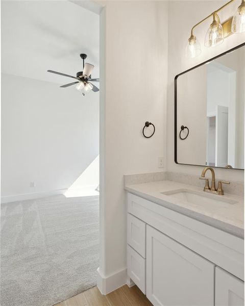 Bathroom featuring vanity, hardwood / wood-style flooring, and ceiling fan