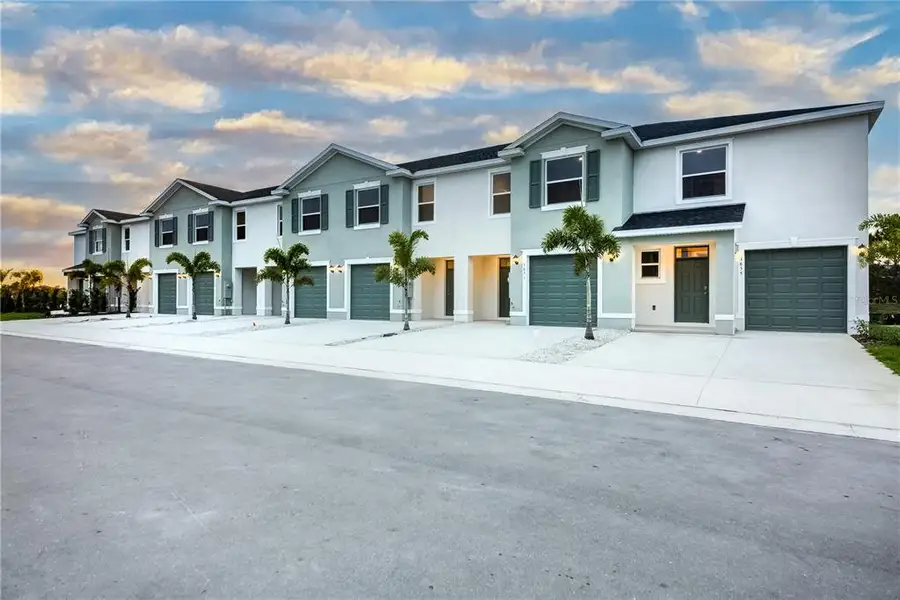 Front exterior of a new home in The Gardens at Bay Street, Sarasota, FL, highlighting curb appeal (Image 1). Front exterior of a new home in The Gardens at Bay Street, Sarasota, FL, highlighting curb appeal (Image 1).