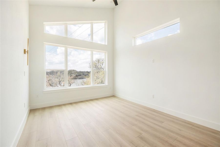 Spare room with light wood-style floors and a high ceiling