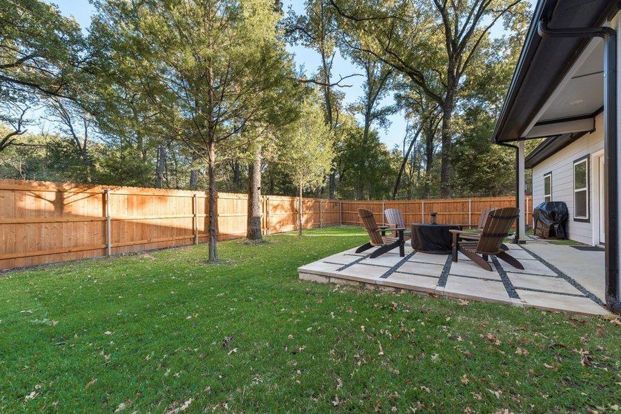 Fenced backyard featuring a patio and an outdoor fire pit
