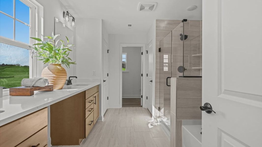 Wynwood home plan primary bathroom with separate vanities, linen closet, tile shower and large bath tub Wynwood home plan primary bathroom with separate vanities, linen closet, tile shower and large bath tub