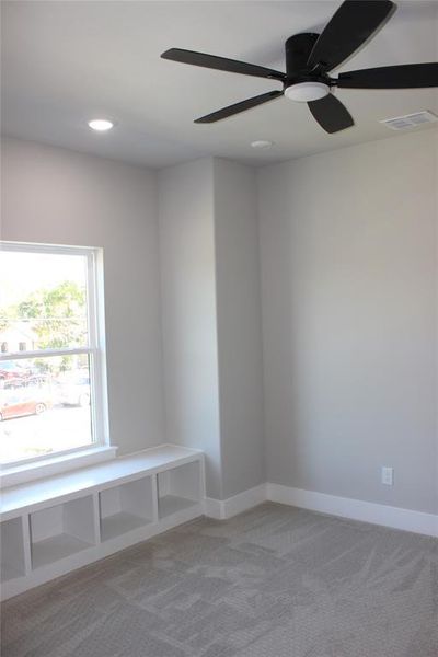 Carpeted spare room featuring ceiling fan