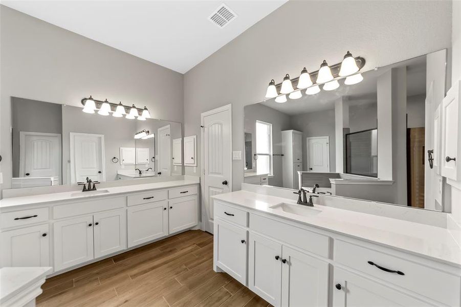 Bathroom featuring a shower with door and vanity