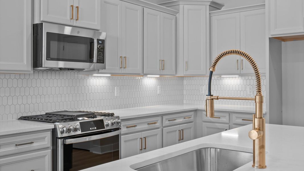 Highly skilled craftsmanship shines in this modern kitchen with pendant lighting and a central island focal point
