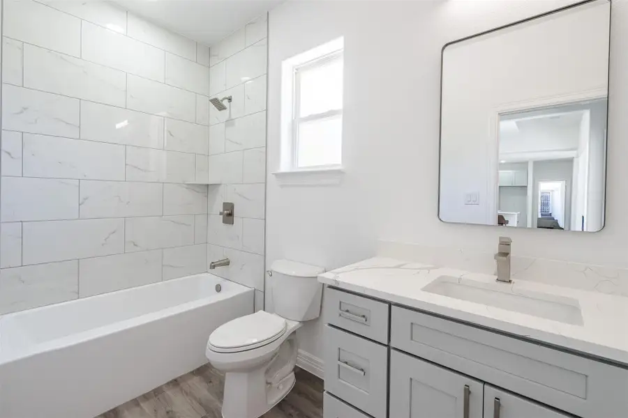 Full bathroom with dark wood finished floors, tub / shower combination, and vanity