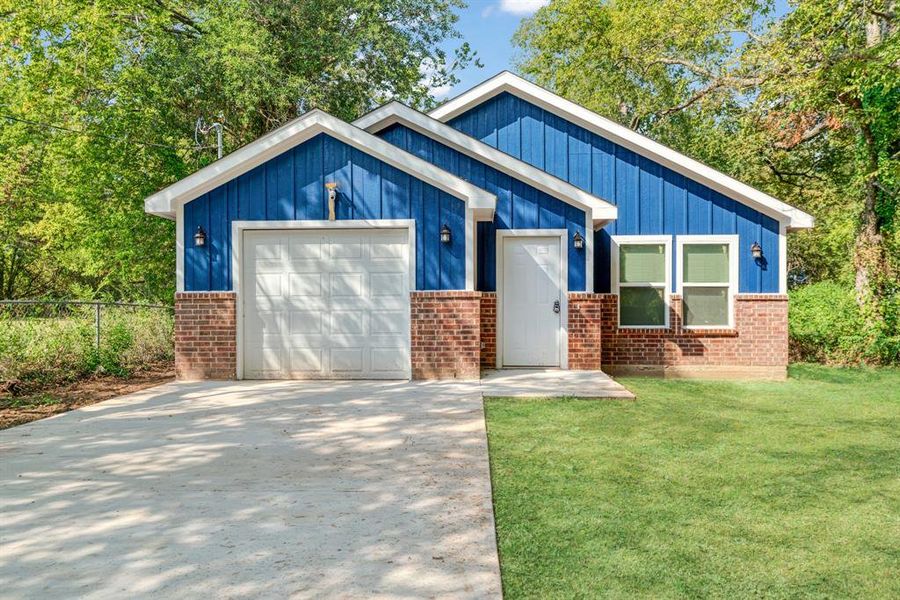 View of front of house featuring brick siding, concrete driveway, a garage, and board and batten siding View of front of house featuring brick siding, concrete driveway, a garage, and board and batten siding