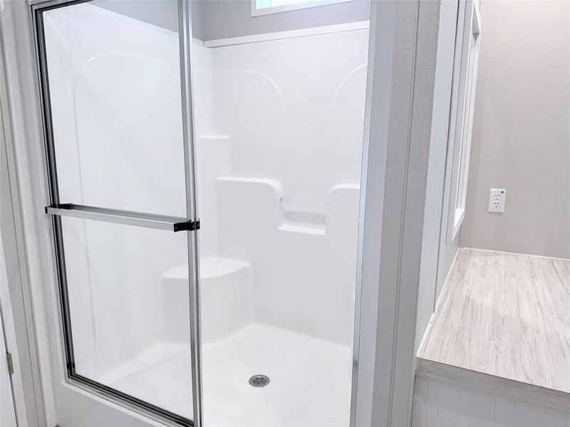 A sleek shower enclosure with a built-in seat enhances this contemporary bathroom.