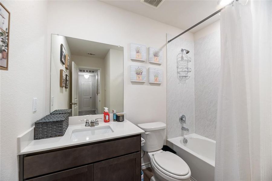 Bathroom with shower / bath combo with shower curtain and vanity
