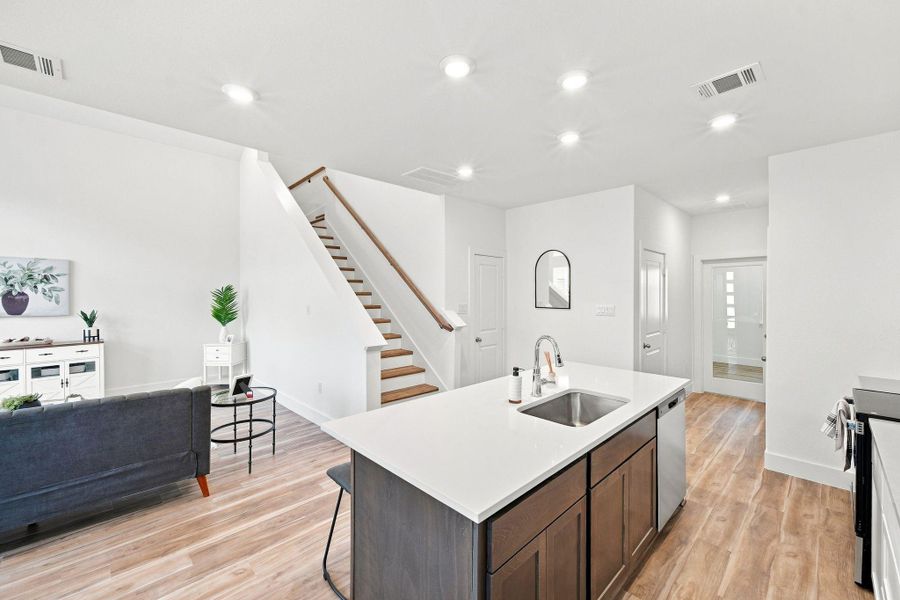 Spacious kitchen island with quartz countertop and seating, seamlessly connecting the kitchen to the living area for an inviting open-concept layout. Spacious kitchen island with quartz countertop and seating, seamlessly connecting the kitchen to the living area for an inviting open-concept layout.