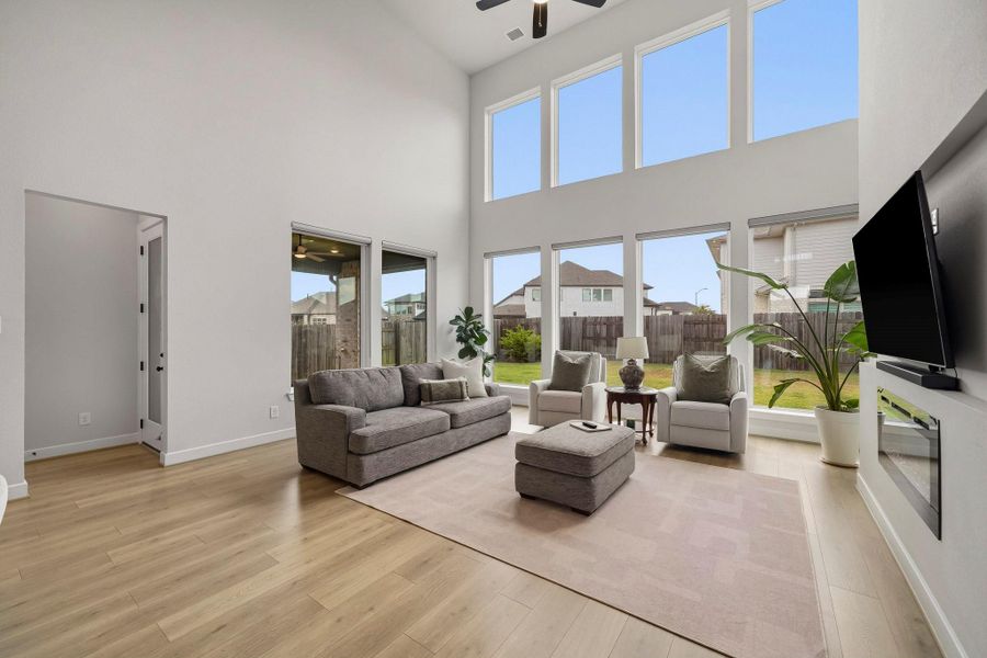 Recessed lighting and a ceiling fan with integrated light add comfort and warmth, while abundant natural light creates a bright, airy living space with an inviting atmosphere.