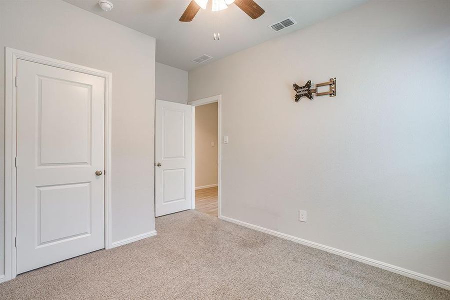 Unfurnished bedroom featuring carpet floors and ceiling fan