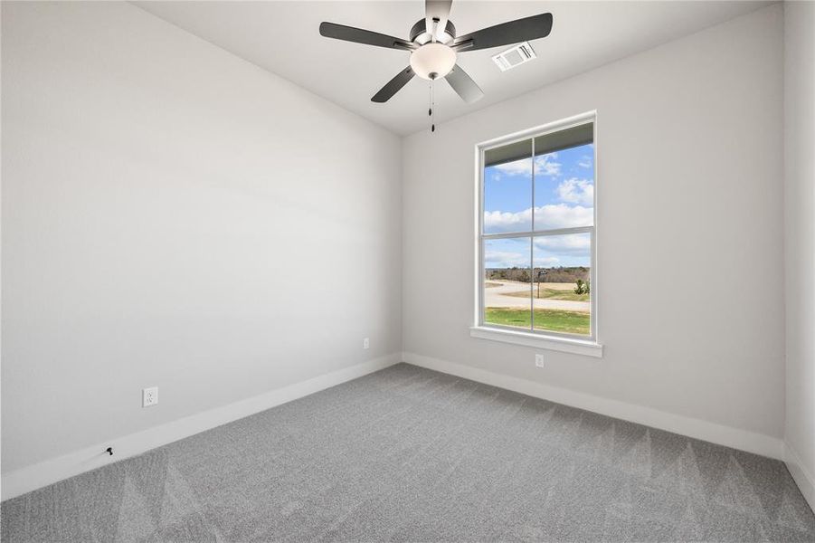 Unfurnished room featuring light colored carpet and a ceiling fan