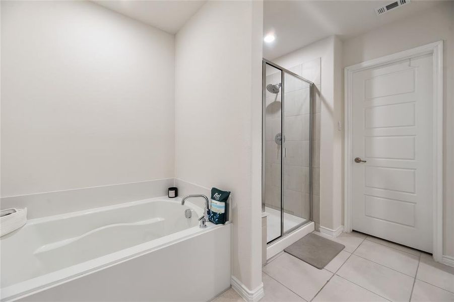 Bathroom with a bath, a shower stall, and light tile patterned flooring