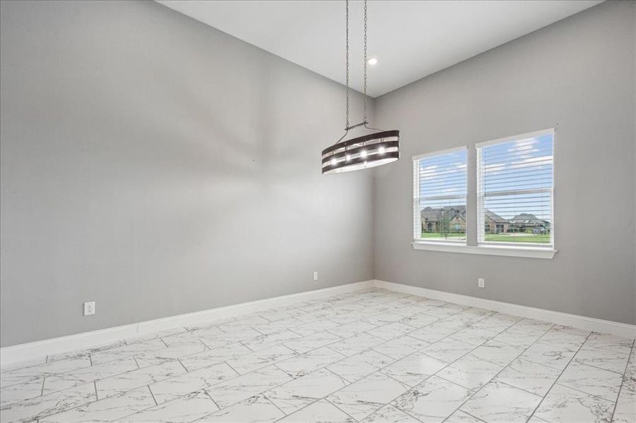 Unfurnished room featuring baseboards and marble finish floor