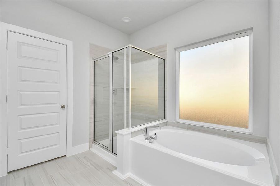 The primary en-suite has a soaking tub to give you that spa experience. The large privacy window allow lots of nature light in the space.