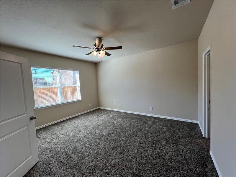 Carpeted spare room featuring ceiling fan