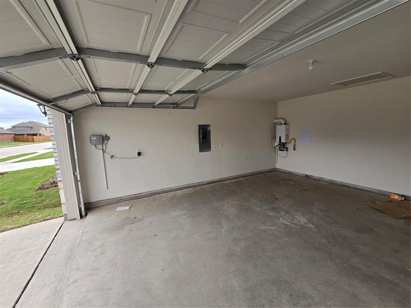 Garage with electric panel and water heater and sprinkler