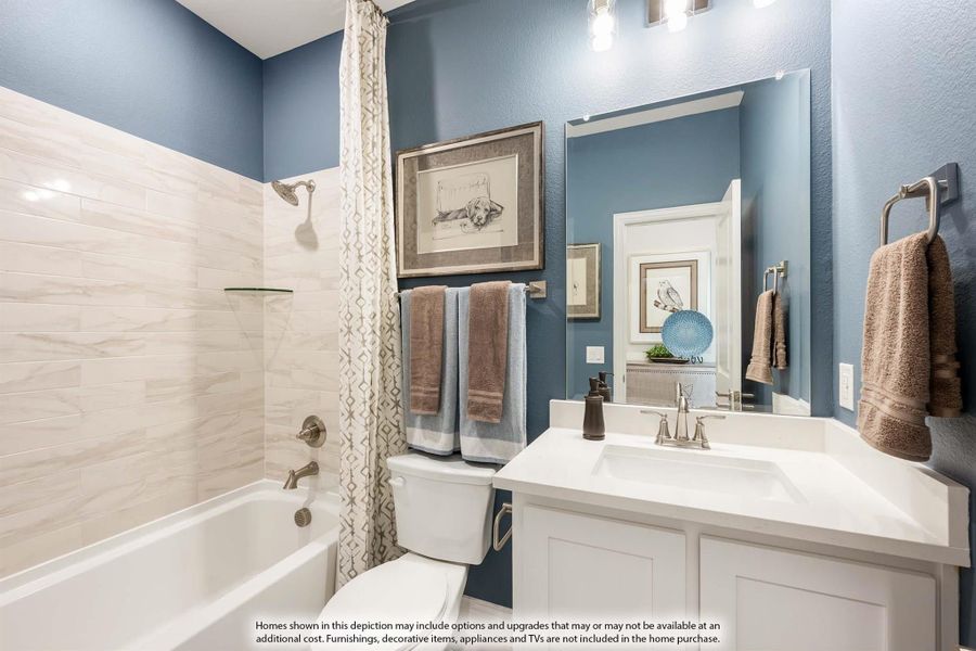 Bathroom with blue walls, white vanity, tiled tub-shower combo, and large mirror
