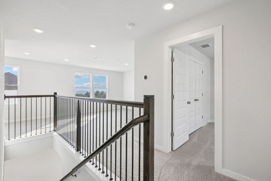 A white room with a black railing.