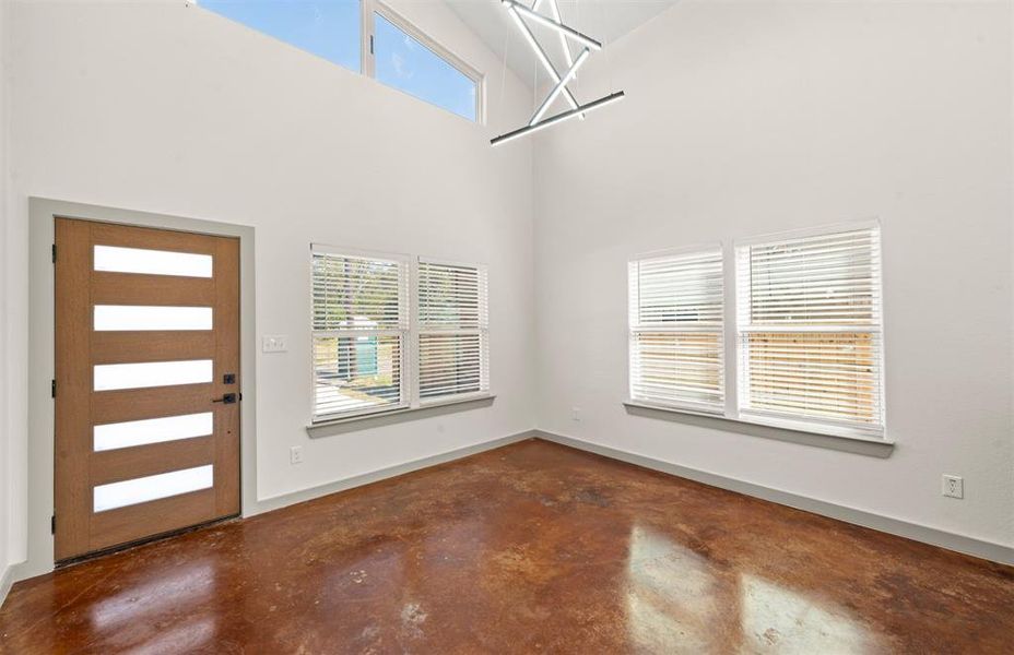 Entrance foyer with concrete floors and a high ceiling