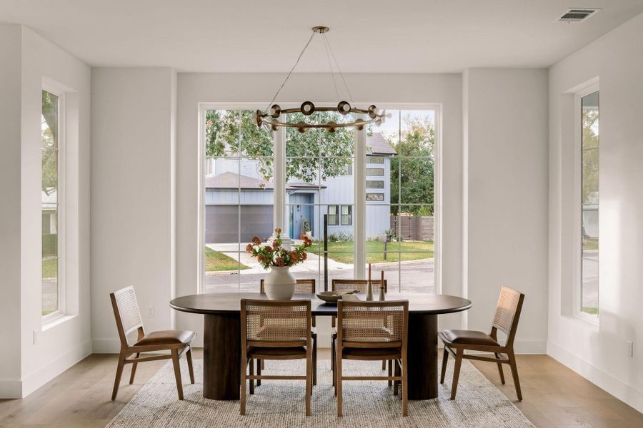 Dining space featuring healthy amount of natural light, a chandelier, and wood finished floors Dining space featuring healthy amount of natural light, a chandelier, and wood finished floors